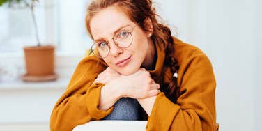 Introvert woman sitting on chair at home, perfectly content.