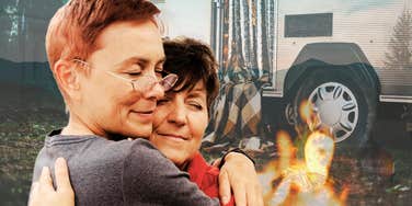 Retired couple embracing by campfire while traveling in trailer
