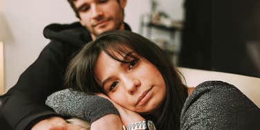 Wife smirking but has sadness in her eyes. 