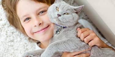 little boy hugging affectionate cat