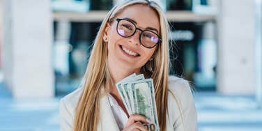 financially responsible woman smiling holding cash