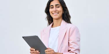 Professional Gen Z woman smiling and looking at the camera.