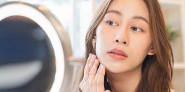woman scrutinizing herself in the mirror
