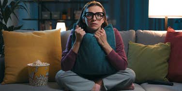 scared woman watching movie with popcorn
