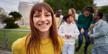 likable young red-haired girl with wide smile and piercing look