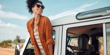 woman leaning out car window on holiday trip