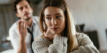 sad woman turned away from yelling man