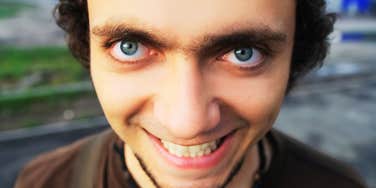 Deranged person, smirking. 