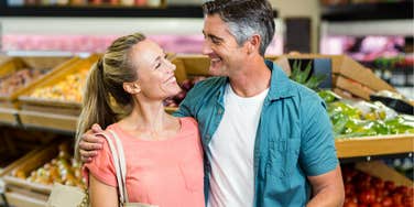 Couple hold hands at grocery store.