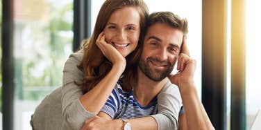 Grown adult couple smiling in home after finding love and making it last 