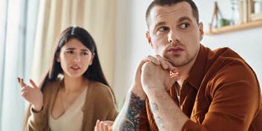 silent upset man turned away from woman he doesnt love