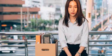 woman sitting with box after quitting job