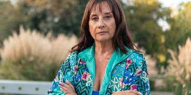 older woman with arms crossed embracing being a loner