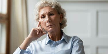 older woman sitting alone not wanting to talk to friends