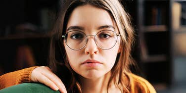 Young, serious woman who chronically attracts negativity