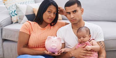 financially stressed middle class family holding a piggy bank