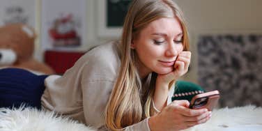 woman scrolling on phone in bed