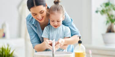 mom teaching her daughter how to wash her hands