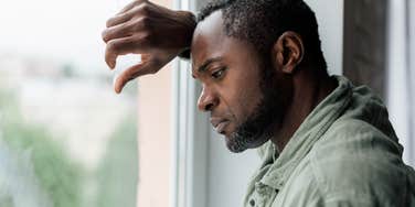 upset man looking out of window