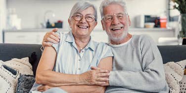 older couple sitting next to each other on couch