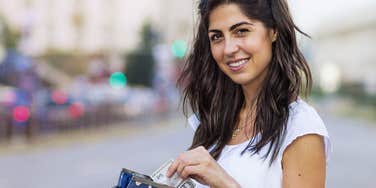 gen z woman saving money in her wallet