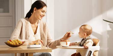 mom feeding baby in momcozy dinerpal high chair