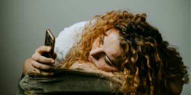 Woman losing interest being on group chat. 