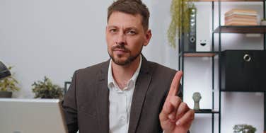 assertive man wagging finger shutting down false accusations