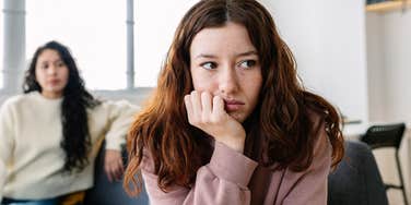 annoyed young woman listening to entitled friend speak