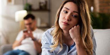 sad woman being ignored by husband thinking of leaving her relationship