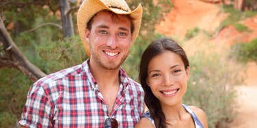 southern couple standing outdoors wearing cowboy hat