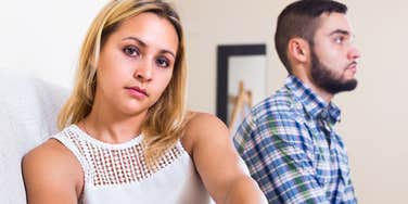 woman looking annoyed sitting next to lazy husband