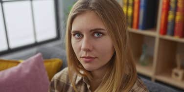 sad woman trying to think among messy home