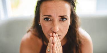stressed woman praying after being made to feel insane