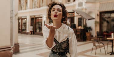 Woman blowing a kiss who knows the simple rule that wins everyone over