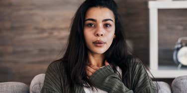 anxious woman thinking someone is talking behind her back