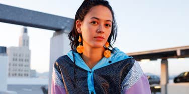 gen z woman sitting outside in 80s colors