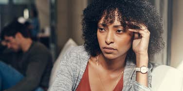 woman holding head in pain from toxic relationship