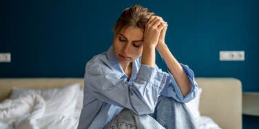depressed woman sitting on bed