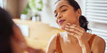 woman making bad hygiene mistake touching her face
