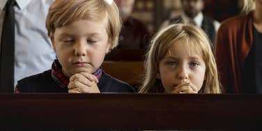 two young kids praying in church are more selfish than kids who grow up in non-religious homes