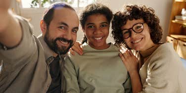 parents with teen daughter smiling teaching her life cheat codes