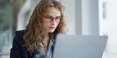woman reading job description with phrases that mean she'll be overworked and undervalued