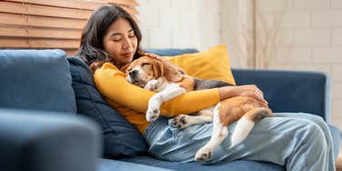 woman cuddling dog like a baby