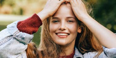 young smiling woman pushing her hair back