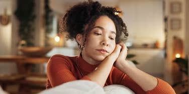 sad woman sitting on her couch