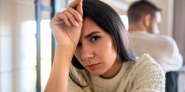 woman feeling uncomfortable with her hand on her head