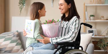 mom in wheelchair holding her daughter in her lap
