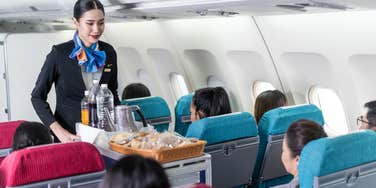 Flight attendant with drink cart
