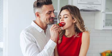 Woman feeling loving because she isn't hungry eating strawberry